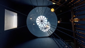 A circular skylight with multiple light fixtures and a window, allowing natural light to enter. - Hotel Kodawari Flores - By Kodawari Residences  (Porto)