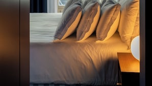 Une chambre d’hôtel avec un lit, une fenêtre avec des rideaux et une vue sur les bâtiments environnants.