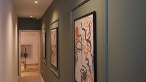 A hallway with artwork on the walls, a carpeted floor, and a door at the end. - Charming studio with AC and WiFi in enchanting Rabat - Studio No. 3  (Rabat)