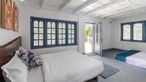 A room with a large bed, two smaller beds, and a door leading outside. - Last Villa (Madikeri)