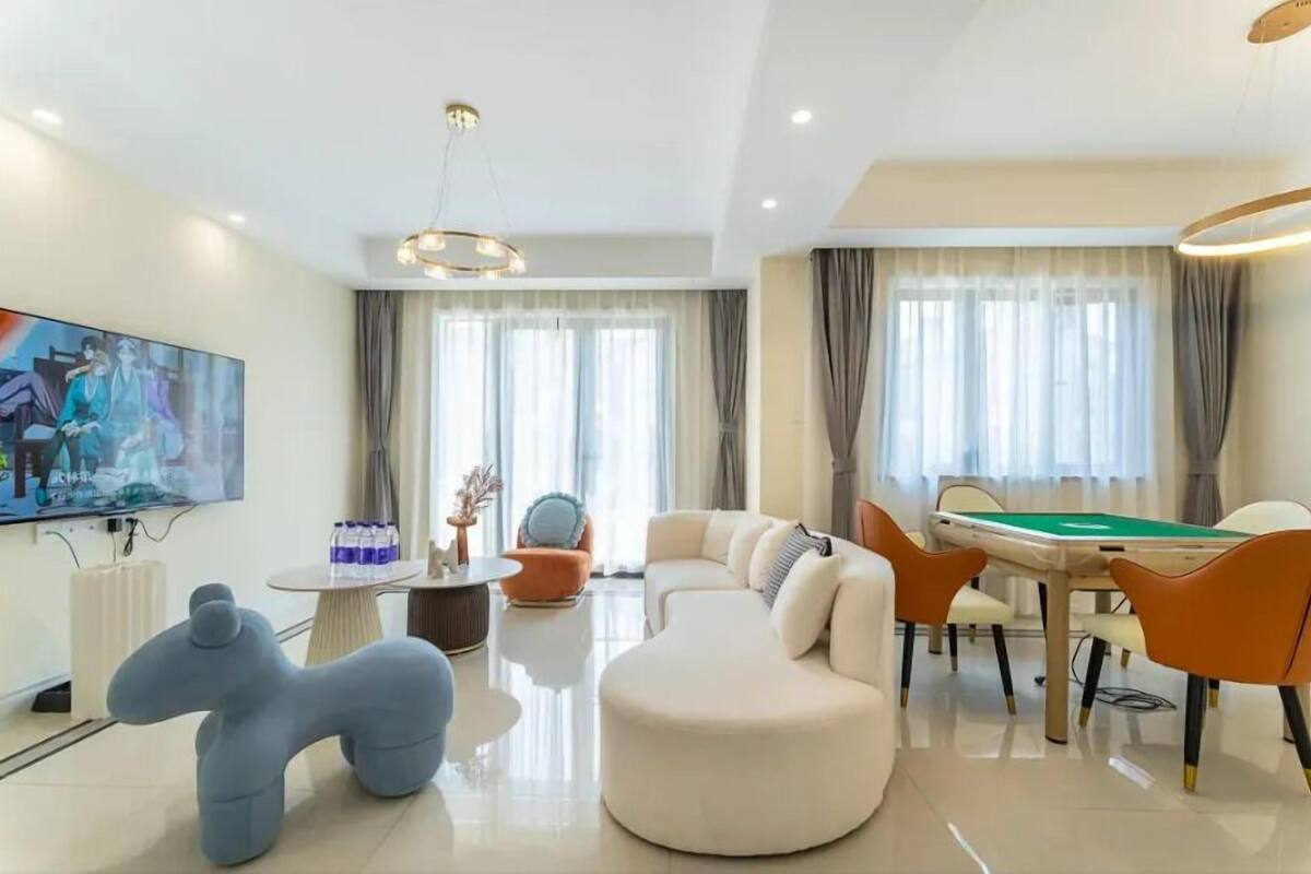 Une chambre d’hôtel moderne équipée d’une table de billard, de fauteuils confortables, d’une grande télévision et d’un coin repas.