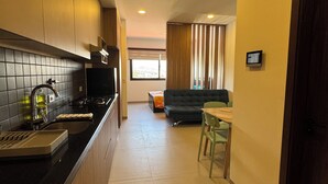 A modern kitchen with a black countertop, a built-in oven, and a window with blinds. - Serene studio with Pool and Wifi in charming Tarija (Tarija)