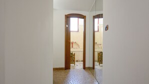 A hallway with a tiled floor leading to a door. - Lovely house with AC in Matera - Perfect for a getaway (Matera)