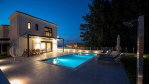 A modern house with a swimming pool, outdoor seating, and a well-lit patio area. - VILLA PENELOPE
 (Katouna)