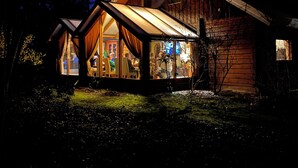 A log cabin with a large glass front, wooden exterior, and a sloped roof. - Spectacular Dune Villa with a private sauna and breathtaking views of the dunes (Soest)