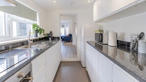 Eine moderne Küche mit weißen Schränken, einer Granitarbeitsplatte und einem eingebauten Backofen.