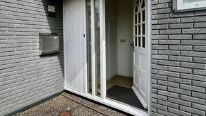 A corner of a building with a white door, a mailbox, and a window. - Beautiful Bungalow in North Holland (Sint Maartensvlotbrug)