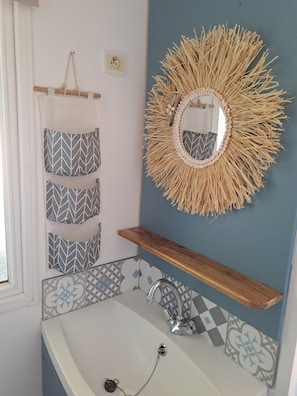 Regadera, secadora de cabello, toallas, papel de baño 