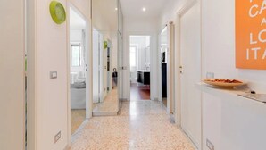 Un pasillo moderno con una cocina visible a través de una puerta abierta.