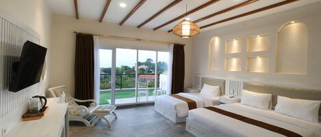 A hotel room with two beds, a desk, a chair, a TV, and a balcony with a view of the outdoors.
