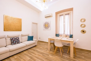 Un salon moderne avec un canapé, une table à manger et une fenêtre avec des rideaux.