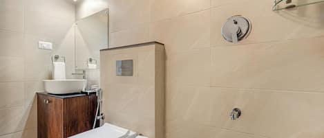 A modern bathroom with a toilet, sink, and shower.