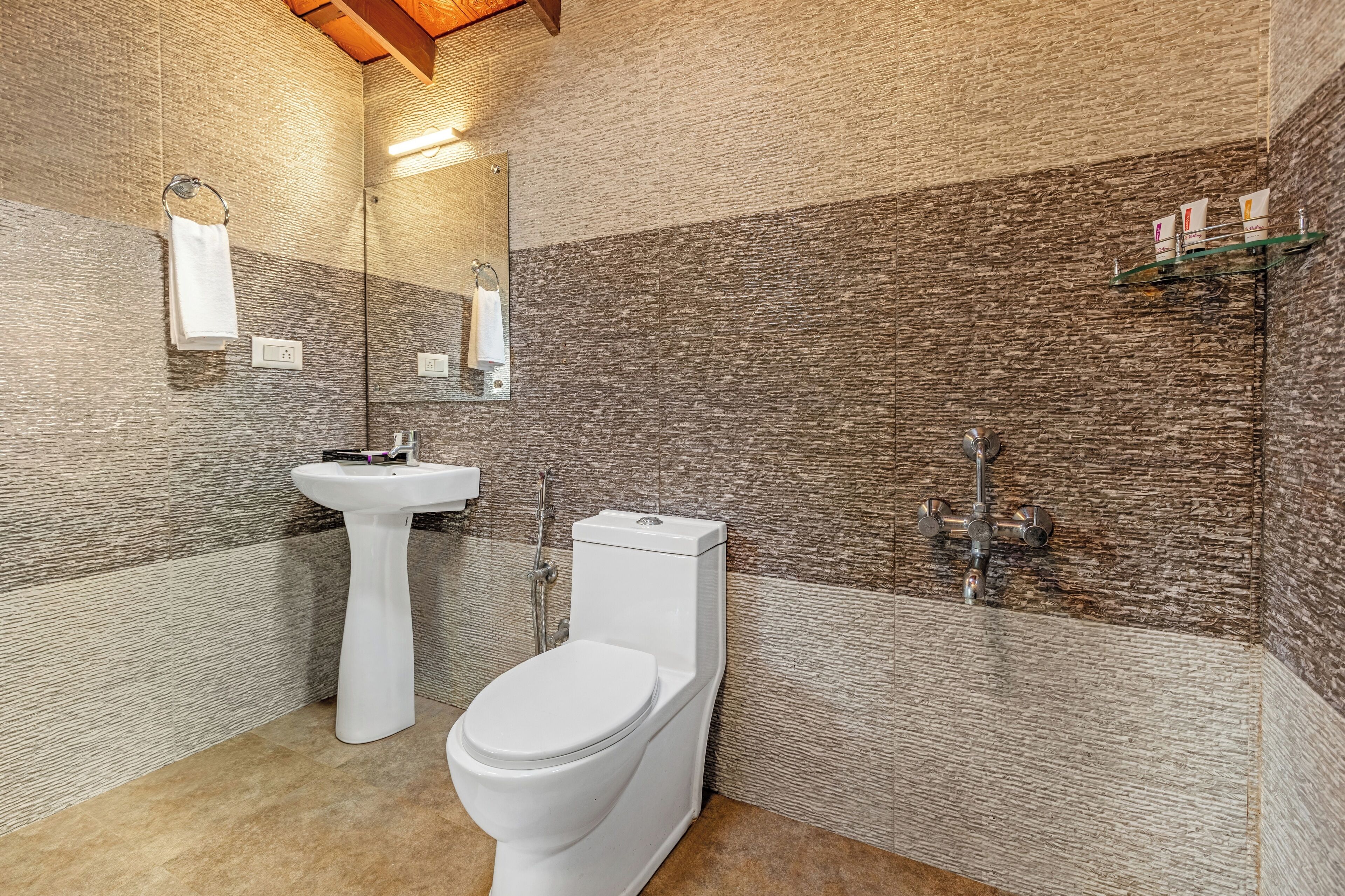 A bathroom with a white toilet, a pedestal sink, and a mirror.