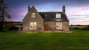 A stone house with a wooden door, two chimneys, and a well-maintained lawn. - Old Duffus Farmhouse on Scottish Estate - stunning castle views (Elgin)
