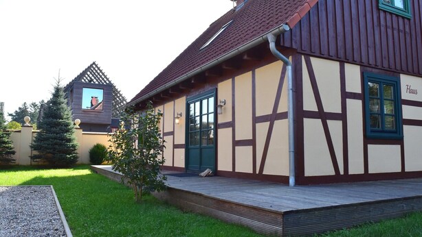 A traditional half-timbered house with a green door and a sign reading "Haus". - Ferienhaus in Wendorf am Seenplatte (Wendorf)