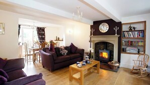 A cozy living room with a fireplace, a sofa, a coffee table, and a bookshelf. - Beautiful characterful cottage,family and dog friendly,quiet,close to amenities  (Harrogate)