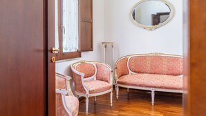 A room with a wooden door, a mirror, and two upholstered chairs with floral patterns. - Siracusa Horizon Home by Wonderful Italy (Syracuse)