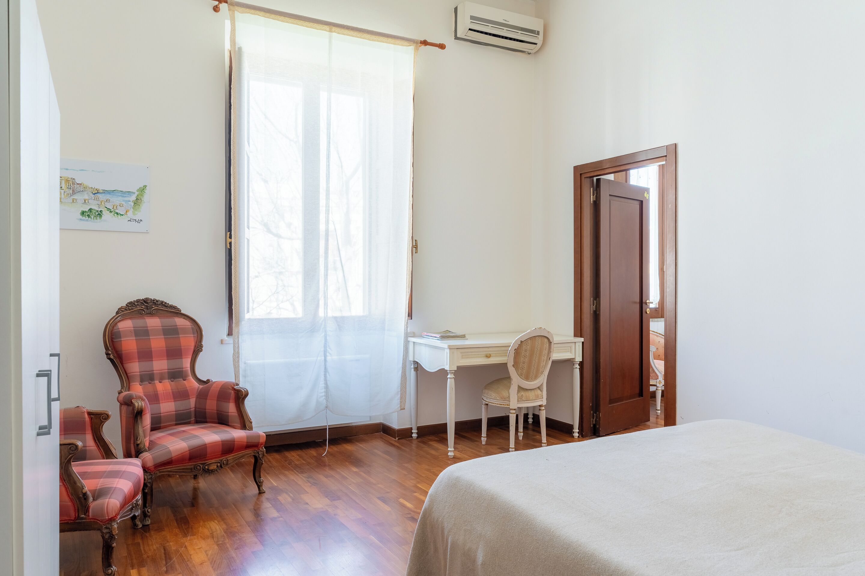 A bedroom with a bed, a desk, a chair, and a wardrobe.