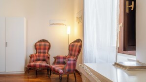 A room with two plaid armchairs, a white cabinet, and a window with a curtain. - Siracusa Horizon Home by Wonderful Italy (Syracuse)