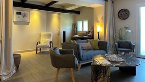 A modern living room with a sofa, armchairs, a coffee table, and a fireplace. - The Bamboo Lodge with its feet in the water (Anduze)