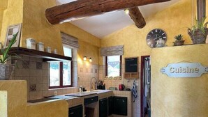 A compact kitchen with a tiled backsplash, wooden beams, and a 'Cuisine' sign. - Beautiful Cevennes farmhouse with swimming pool (Corbès)