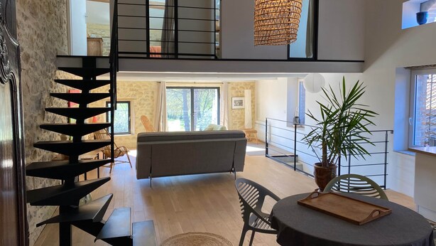 Un interior moderno con una escalera, un comedor y vistas al exterior.