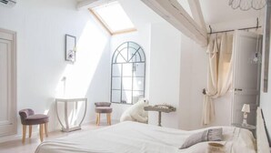 A bedroom with a large bed, a skylight, a window, and a polar bear statue. - Le mas d'Elise, in the heart of the Cévennes countryside (Saint-Hippolyte-de-Caton)