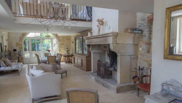 A spacious living room with a fireplace, a dining area, and a view of the outdoors. - Le mas d'Elise, in the heart of the Cévennes countryside (Saint-Hippolyte-de-Caton)