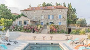 A stone building with a swimming pool and outdoor seating. - Le mas d'Elise, in the heart of the Cévennes countryside (Saint-Hippolyte-de-Caton)
