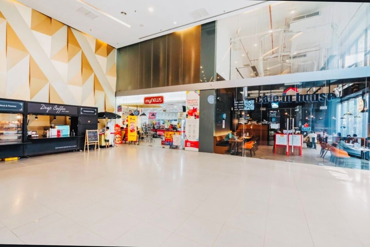 Un vaste centre commercial avec un café appelé « Drop Coffee » et un restaurant appelé « My News ».