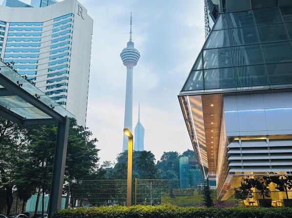 A modern urban landscape with a prominent tower and surrounding high-rise buildings.