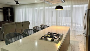 Uma cozinha moderna com ilha central, fogão a gás e ventilador de teto.