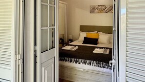 A hotel room with a bed, a nightstand, a wall art piece, and a ceiling light. - Green House | Mountain Green Views & Sea Glimpse | Calheta (Calheta)