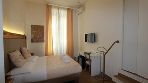 A hotel room with a bed, a desk, a TV, and a staircase. - Art Atelier Accomodation Camera 1 (ROMA)