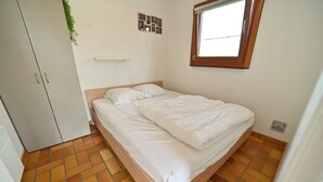 A bedroom with a bed, a wardrobe, a window, and a tiled floor. - Chalet in Viroinval Near Nature Park (Viroinval)