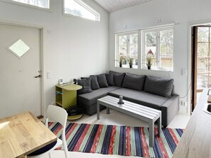 A modern living room with a sectional sofa, a small table, and a colorful striped rug. - 3 Person Holiday Home in Solvesborg (Sölvesborg)