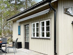 A building with a beige exterior, a black door, and a window with a white frame. - 3 Person Holiday Home in Solvesborg (Sölvesborg)