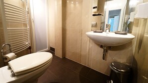 Une salle de bain moderne avec des toilettes, un lavabo et un miroir.