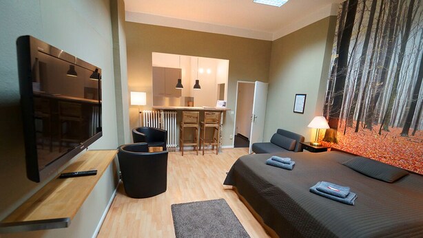 Une chambre d’hôtel moderne équipée d’un grand lit, d’une télévision, d’un bureau et d’un coin repas.