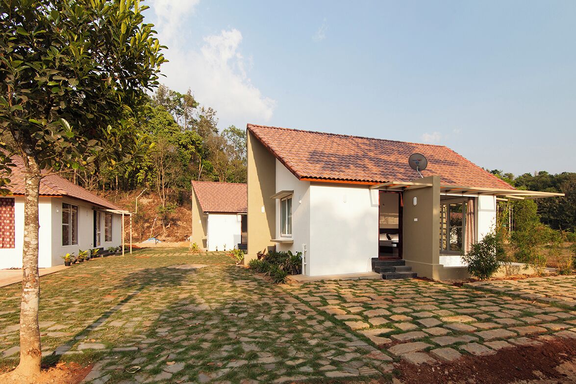 A modern two-story house with a tiled roof, a paved driveway, and a well-maintained lawn.