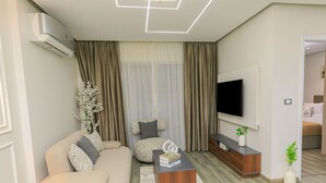 Un salon moderne avec un canapé, une table basse, un téléviseur et une plante.