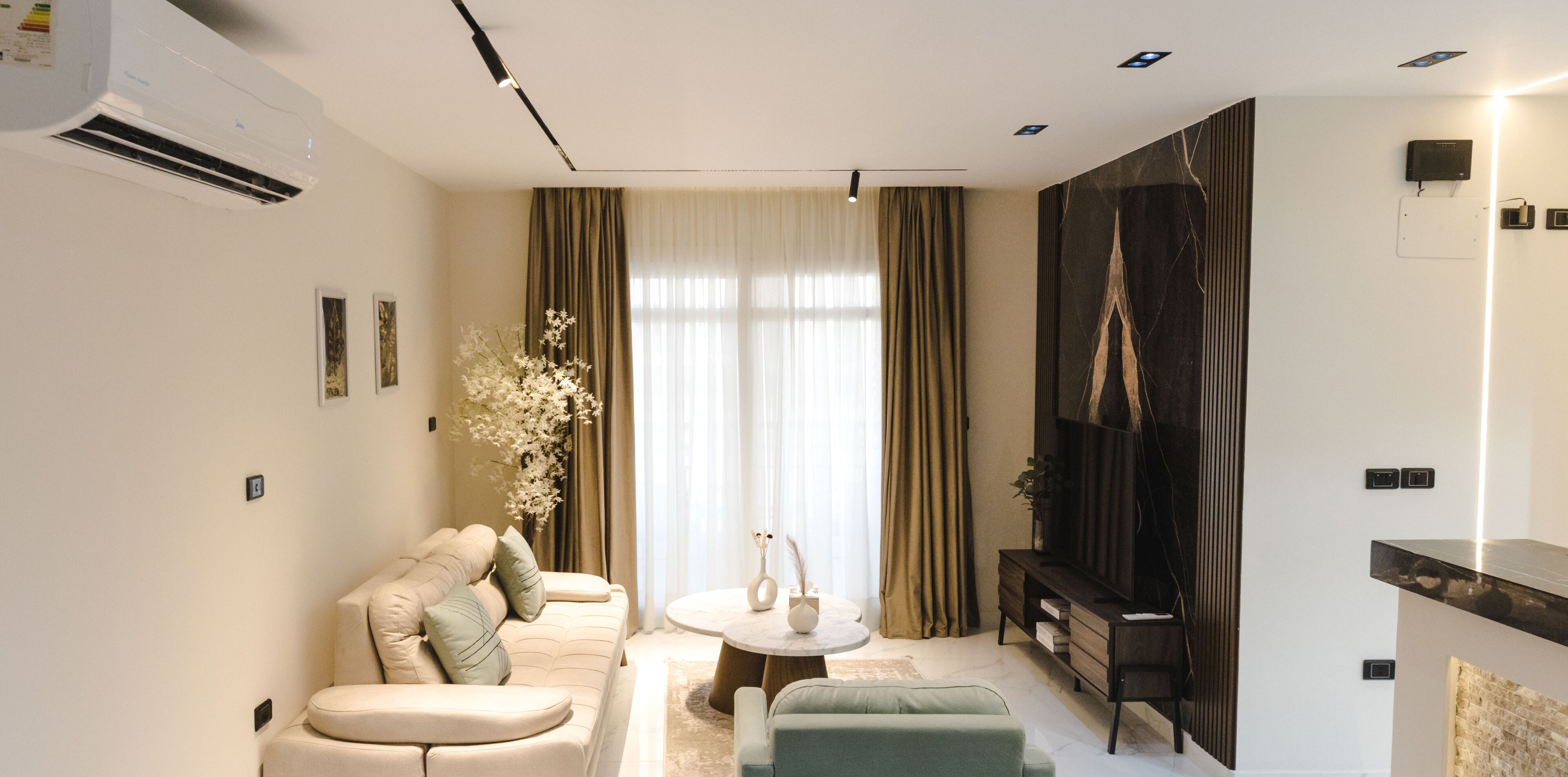 A modern living room with a sofa, a coffee table, and a TV.