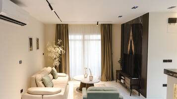 A modern living room with a sofa, a coffee table, and a TV.