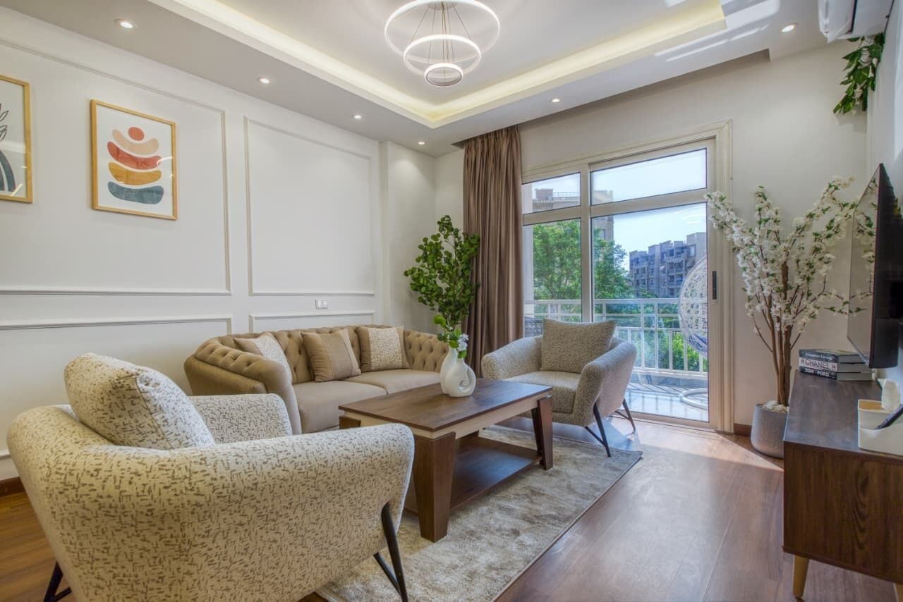 A modern living room with a sectional sofa, a coffee table, and a TV stand.