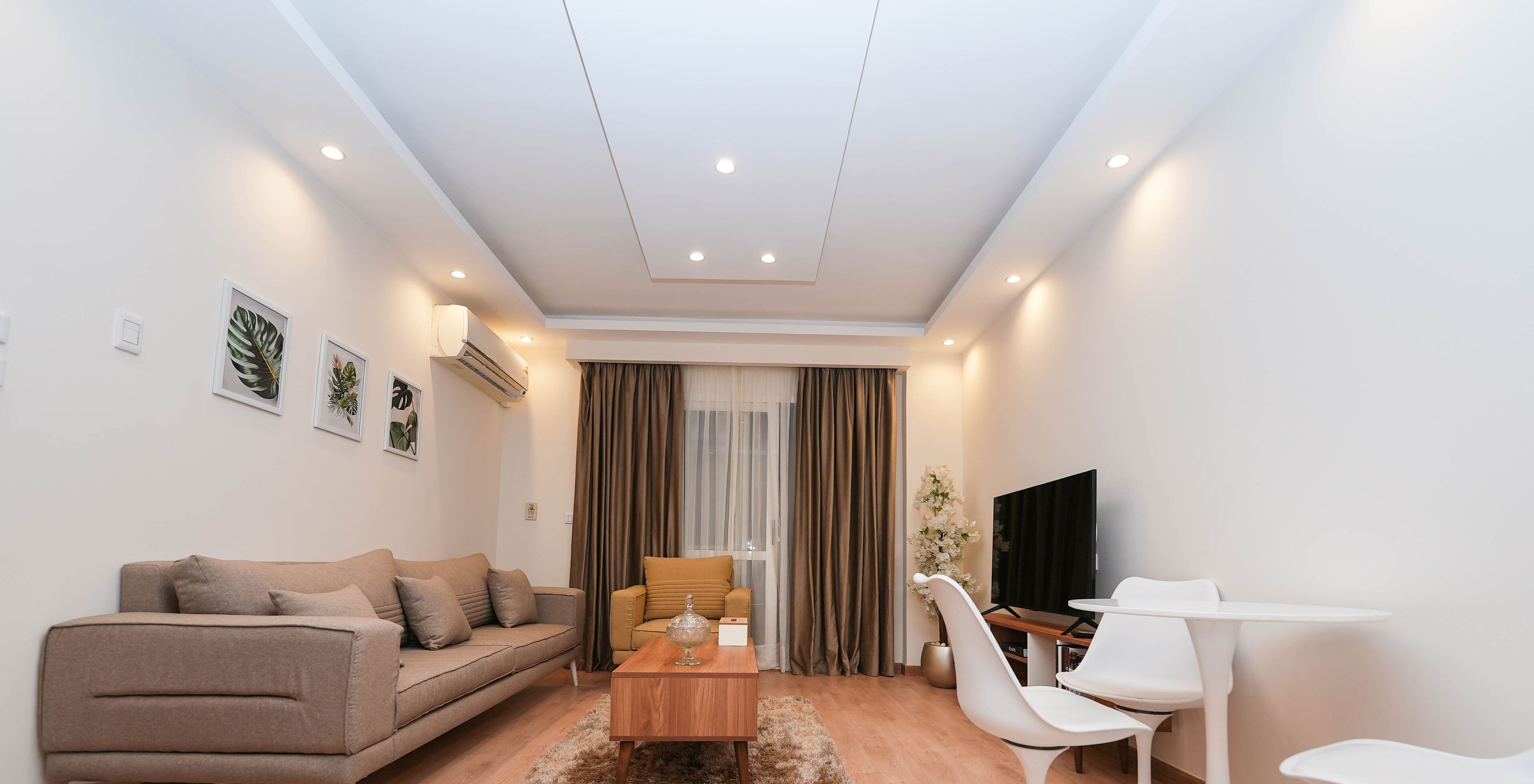 A modern living room with a sofa, coffee table, and a TV.