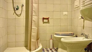 Un baño con ducha, inodoro y lavamanos.