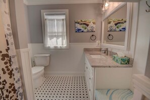 Une salle de bain avec des toilettes, un lavabo et une fenêtre.