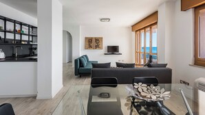A modern living space with a kitchen, dining area, and seating area. - Una Finestra Su Cala Rossa by Wonderful Italy (Syracuse)
