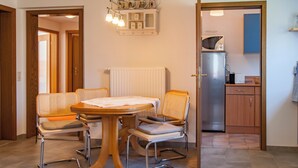 Un comedor con mesa y sillas, una cocina equipada y un radiador.