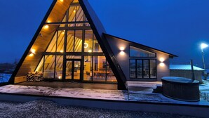 Un edificio moderno triangular con grandes ventanales y el suelo cubierto de nieve.